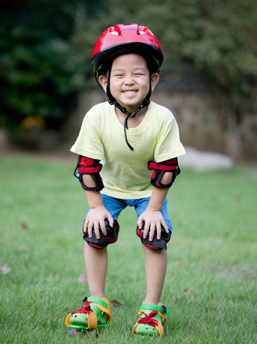 boy with helmet and pads on elbows and knees