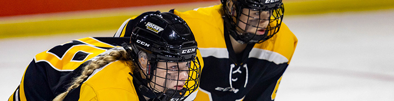 deux jeunes en maillots et casques jouent au hockey