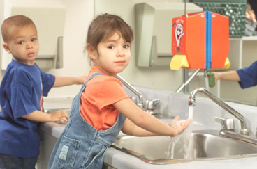 Two kids at sink washing hands